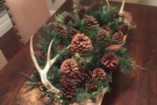 26 a woodland fall centerpiece of a dough bowl with evergreens, pinecones of various kinds and antlers for autumn