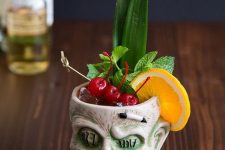 28 a tropical Halloween cocktail with citrus, cherries, greenery is a catchy idea, serve it in a skull