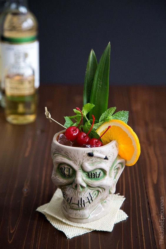 a tropical Halloween cocktail with citrus, cherries, greenery is a catchy idea, serve it in a skull