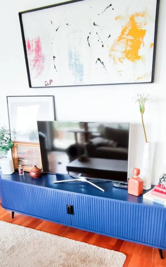 a super bold blue fluted TV console made of an IKEA Kallax piece, with a TV and some lovely decor