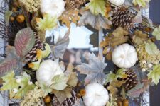 34 a fall wreath of pinecones, leaves, pumpkins, nuts and other stuff is a beautiful fall decoration with a lot of natural touches