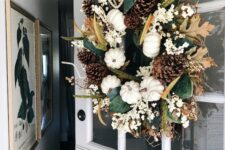 35 a fall wreath of pumpkins, leaves, white blooms, pinecones and twigs is a lovely rustic decoration