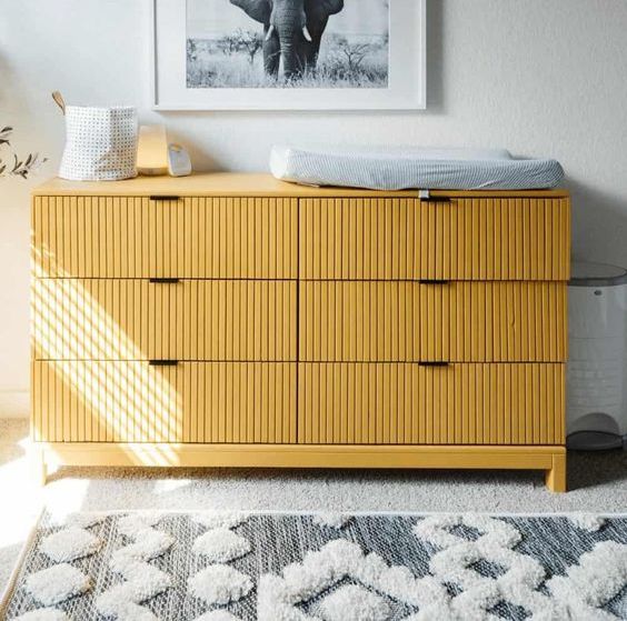 a yellow IKEA dresser done with fluting as a changing table for a nursery is a lovely and chic solution