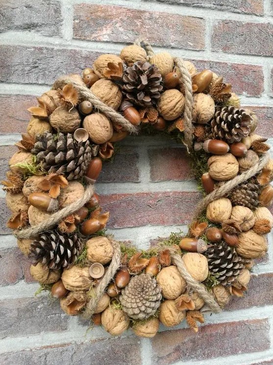 a natural rustic wreath of nuts and acorns, pinecones and rope plus some moss is a cool and chic idea for the fall