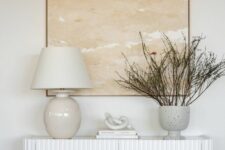 38 an elegant white fluted piece with a table lamp, a vase with branches and coffee books is a cool idea for any entryway