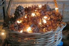 40 a basket filled with pinecones and lights is a cute and very simple fall or winter decoration
