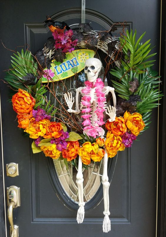 a crazy tropical Halloween wreath with tropical leaves and blooms, a skeleton ith a flower necklace