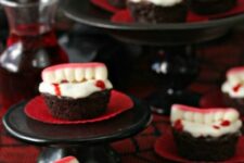 43 Halloween cupcakes topped with edible vampire teeth are a cool and fun Halloween dessert idea