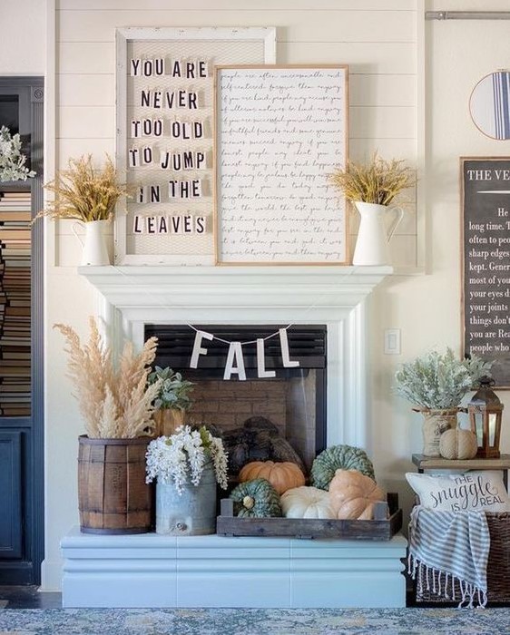 fall fireplace styling with a tray with heirloom pumpkins, blooms and wheat in a wooden bucket plus wheat in jugs on the mantel