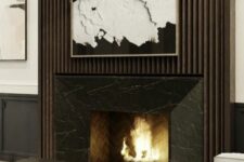 45 a refined contemporary living room with a fireplace with a black marble surround and a fluted one, dark and white furniture