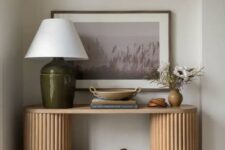 46 a beautiful entryway console table with fluted legs, a table lamp, some decor, an artwork and a basket for storage is all cool