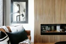 48 a stylish modern living room with a fireplace clad with a reeded surround, with a leather sofa and black and white pillows, a low coffee table