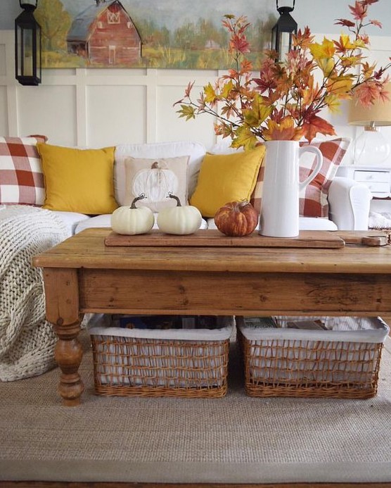 a bold fall leaf arrangement in a jug and some natural pumpkins for a rustic fall coffee table
