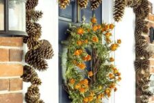 52 gilded pinecones covering the doorway and a dried bloom wreath make the porch very fall-like