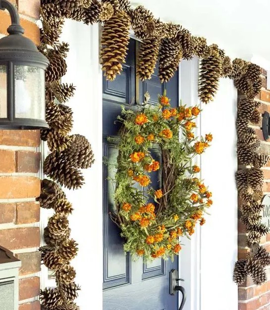 gilded pinecones covering the doorway and a dried bloom wreath make the porch very fall-like