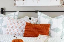 61 a bold orange pillow, a plaid blanket and a fabric pumpkin in a basket for a fall touch in the living room
