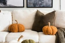 62 a living room with funny and fluffy pumpkin-shaped pillows is a cool and cozy space with a strong fall feel
