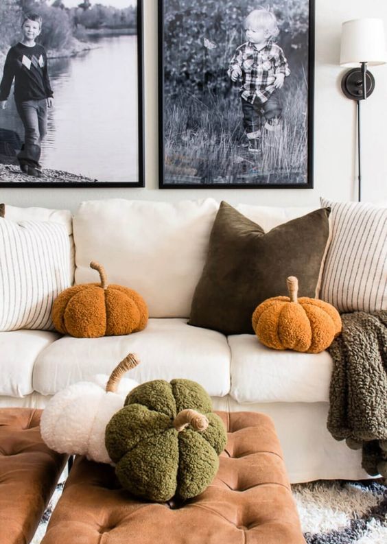 a living room with funny and fluffy pumpkin-shaped pillows is a cool and cozy space with a strong fall feel
