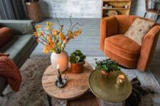 63 a rust-colored chair, blanket, bright coffee tables and bold orange blooms add fall coloring to the living room