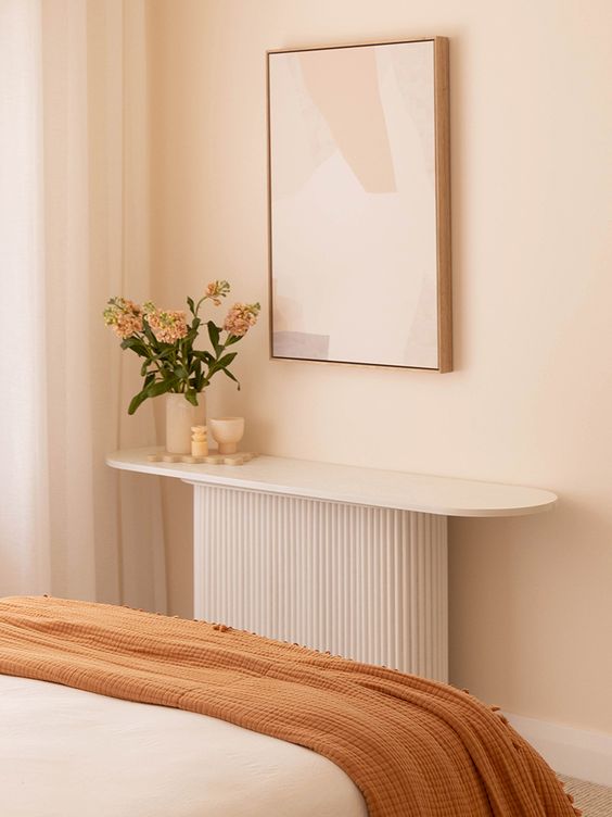 a small and cool console table with a fluted base and a sleek oval tabletop is a lovely addition to any room