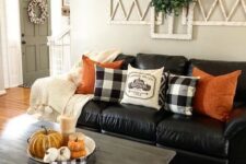 67 bright orange pillows and a bowl with pumpkins and candles are added for a fall touch