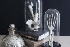 Halloween decor with books and cloches containing skeleton fragments is a lovely idea for a modern space, you can make these quickly
