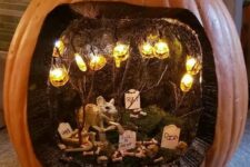 a Halloween diorama with jack-o-lantern lights, a rat, a graveyard and moss is a lovely idea for the holiday
