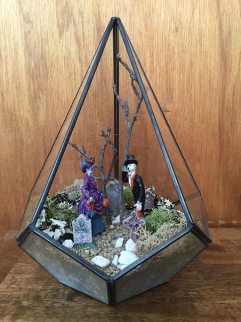 a Halloween terrarium with skeletons and a graveyard is a small and cute scene for party decor