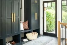 a black and white mudroom in farmhouse style, with large wardrobes, a built-in bench, a printed rug and a glass door