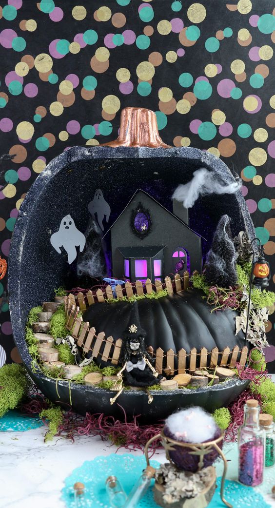 a black faux pumpkin with a pumpkin inside, a fence, a tree stump staircase, some ghosts and a skeleton