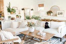 a boho meets modern farmhouse neutral living room with creamy seating furniture, brown leather chairs, a blue rug and a coffee table