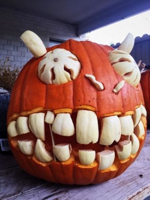 a bold and spooky Halloween pumpkin with large teeth, eyes and horns made of another, white pumpkin