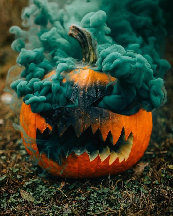 a carved Halloween pumpkin with a green smoke bomb inside will make your Halloween photos ultimate