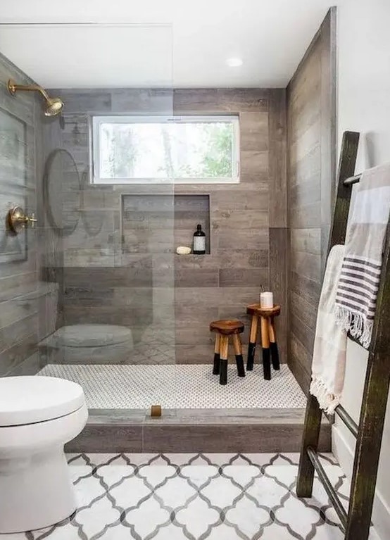 a contemporary farmhouse bathroom with mosaic tiles on the floor, wood inspired tiles in the shower and a large ladder