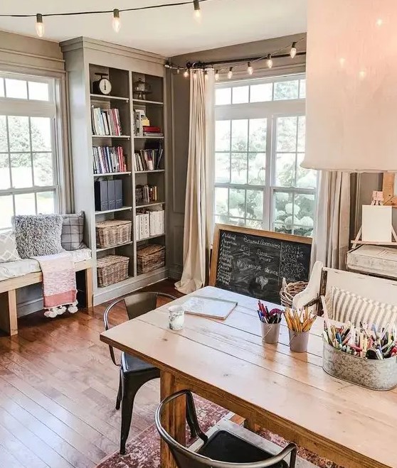 a cottage home office with a wooden desk, a chalkboard sign, a built in storage unit and a bench is very welcoming and cool