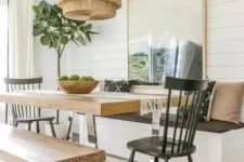 a cozy dining space with a table on a metal base and matching benches that repeat the table design