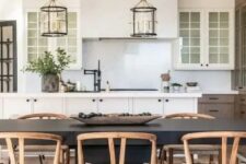 a farmhouse dining space with a black dining table, stained wishbone chairs, a cowhide rug and a kitchen zone next to it