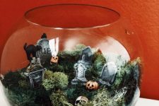 a fish tank with moss, tombstones, jack-o-lanterns and a black cat is a lovely idea for Halloween decor and it’s easy to make
