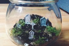 a jar with a lid with moss and greenery and a minig raveyard inside is a cool solution for Halloween