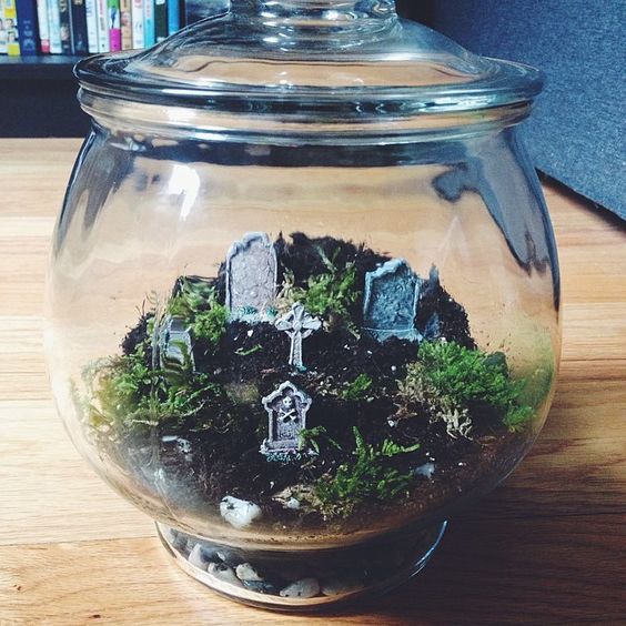 a jar with a lid with moss and greenery and a minig raveyard inside is a cool solution for Halloween