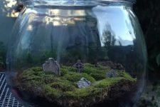 a jar with moss and a mini graveyard is a beautiful and realistic decoration for Halloween
