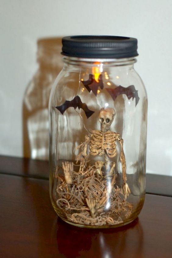 a mini Halloween terrarium with hay, a skeleton, bats and lights is a cool solution to rock, you can make it easily