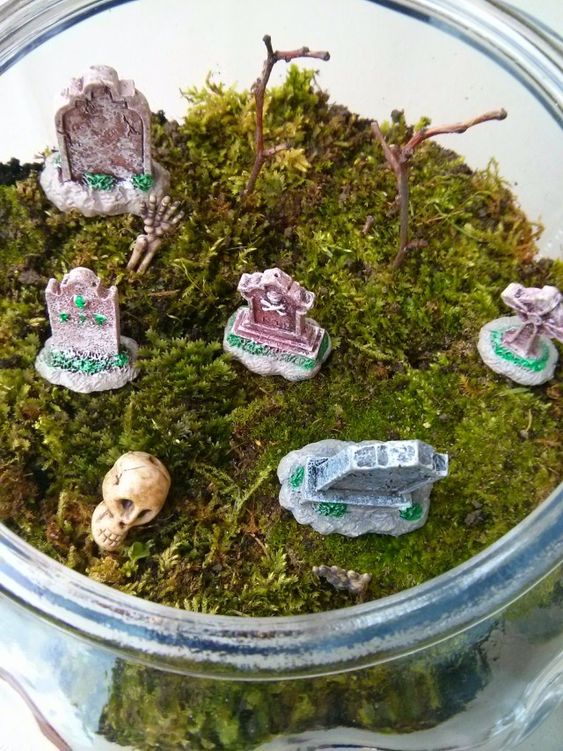 a mini Halloween terrarium with moss, tombstones and a skull can be made in some minutes