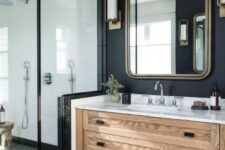 a modern farmhouse bathroom with a stained vanity, a mirror in a metal frame, a shower and black walls and floor