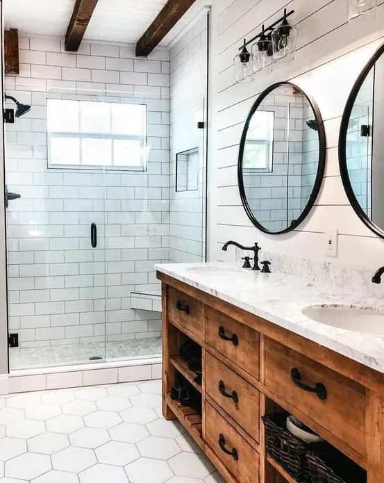 a modern farmhouse bathroom with a stained vanity, hex tiles on the floor and dark wooden beams