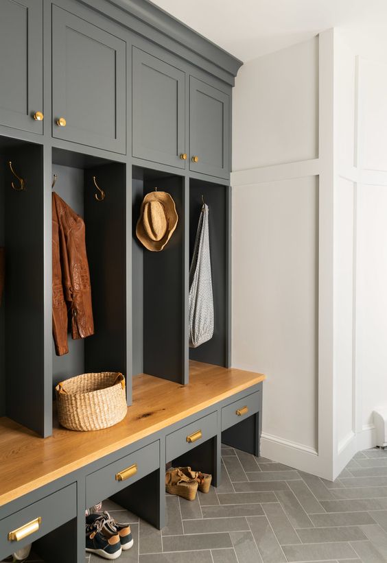 a modern farmhouse grey mudroom with built-in cabinetry, gold handles is a welcoming space