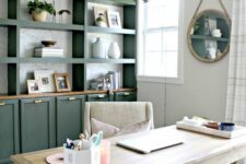 a modern farmhouse home office with a large green storage unit, a whitewashed trestle desk, a neutral chair and a pendant lamp