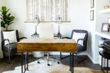 a modern farmhouse home office with a stained desk, black chairs, a built-in storage unit and a cowhide rug
