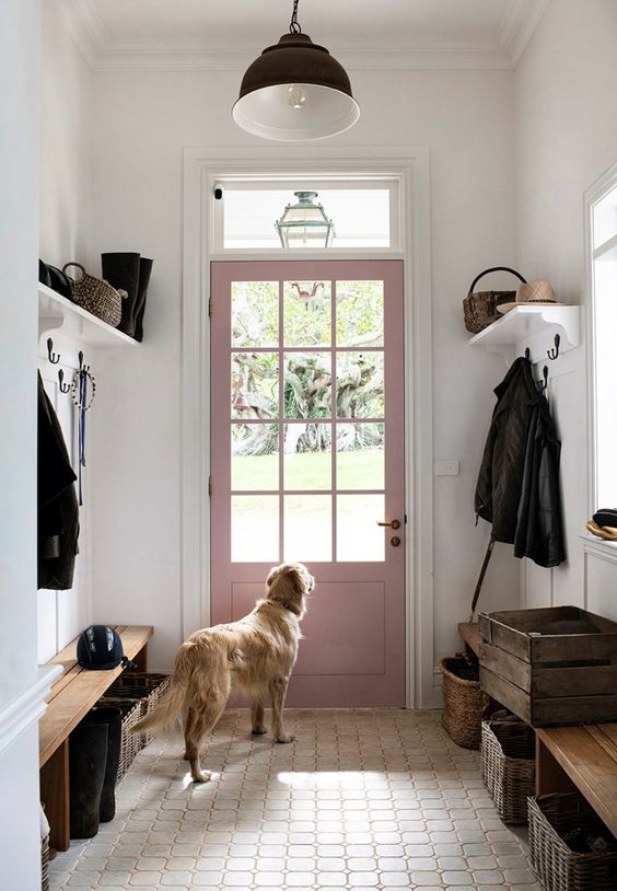 a modern farmhouse mudroom with benches and baskets, racks and a black pendant lamp is a welcoming space