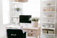 a neutral modern farmhouse home office with white storage units, a whitewashed desk, a black chair, a woven pendant lamp